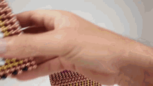 a person is holding a bunch of magnetic beads in their hands