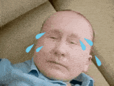 a man with tears coming out of his eyes is wearing a blue shirt