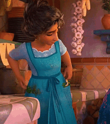 a woman in a blue dress is standing in front of a bunch of garlic