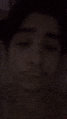 a close up of a young man 's face with his eyes closed and a mustache .