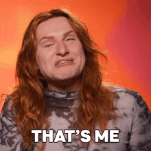a man with long red hair is making a face and the words that 's me are above him