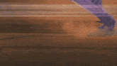 a person is walking on a wooden surface with a purple light coming out of their feet .