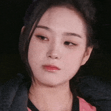 a close up of a young woman 's face with a black background