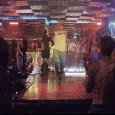 a man in a white shirt is dancing in front of a crowd