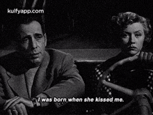 a man and a woman are sitting next to each other in a black and white photo .