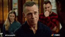 a man in a blue shirt is standing in front of a group of people with the hashtag #chicagopd on the bottom
