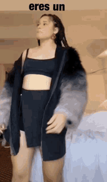 a woman is wearing a fur coat and a black crop top .