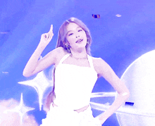 a woman wearing a white top and earrings is dancing on a stage