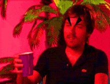 a man in a black lacoste shirt holds a blue cup