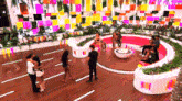 a group of people are gathered in a large room with a pink couch