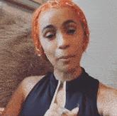 a woman with orange hair is wearing a black shirt