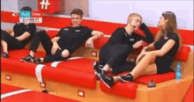 a group of people are sitting on a couch in a room .
