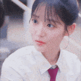 a close up of a girl wearing a white shirt and a purple tie
