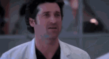 a close up of a man wearing a lab coat and a black shirt .
