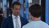 a man in a suit and tie is talking to another man .