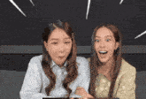 two women sitting next to each other with one wearing a striped shirt with the letter o on it