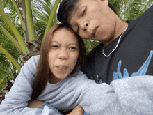 a man and a woman are posing for a picture and the man is wearing a shirt that says ' a '