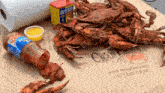 a bottle of old bay sits on a table with crabs