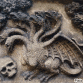 a statue of a dragon with many heads and a skull on the bottom