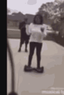a girl is riding a hoverboard on a sidewalk .
