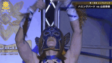 a woman in a blue mask is hanging upside down with a #pwmg logo behind her