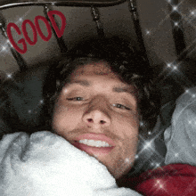 a man laying in bed with the word good written in red