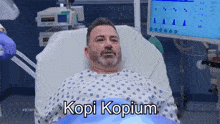 a man laying in a hospital bed with the words kopi kopium written on the bottom
