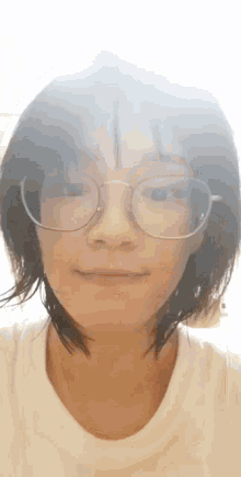a close up of a woman wearing glasses and a white t-shirt .