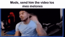 a man in a blue shirt is sitting in front of a screen with the words `` mods send him the video los meo melones ''