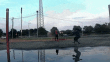a person riding a skateboard in a puddle with their reflection in it