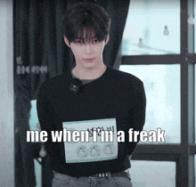 a young man wearing a black shirt with the words me when i 'm a freak written on it
