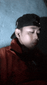 a man wearing a hat and ear buds has a sticker on his jacket that says ' police ' on it