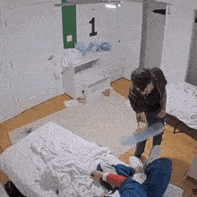 a person standing next to a bed with a number 1 on the wall