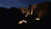 a house is lit up at night with a car parked in front of it