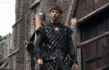 a man in armor is standing in front of a building with the words lord-aldrem gifs written on the bottom