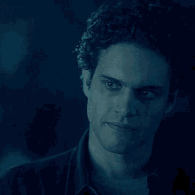a close up of a man 's face in a dark room with his eyes closed .