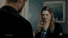 a man and a woman are standing next to each other in a living room .