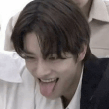 a young man is sticking his tongue out while laughing .