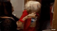 a blurry picture of two women with a sbt logo on the bottom right