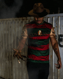 a man wearing a shirt that says covenant is holding a knife