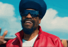 a man wearing sunglasses and a blue turban is smiling