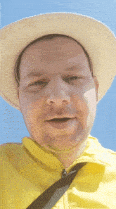 a man wearing a yellow jacket and a white hat