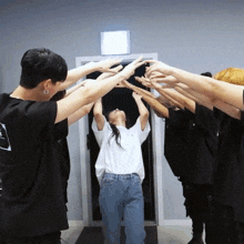 a group of people are standing in a circle with their hands up