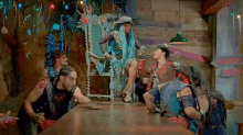 a group of people are sitting around a table and a woman is sitting on a throne .