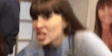 a close up of a woman making a funny face while standing next to another woman .