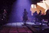 a group of people are standing in a dark room with purple lights shining on them