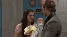 a man and a woman holding a baby in their arms