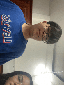 a man wearing a blue levi 's shirt stands next to a woman