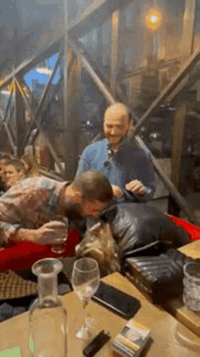 a group of people are sitting at a table drinking wine .