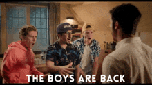 a group of boys are standing around a man with the words " the boys are back " written on the bottom